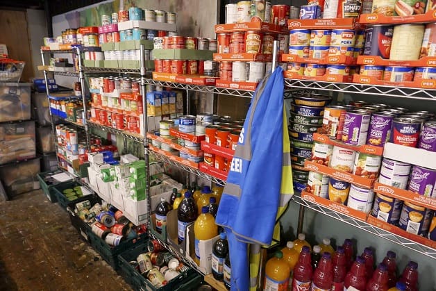 Food bank shelving filled with donated tinned food ready for distribution